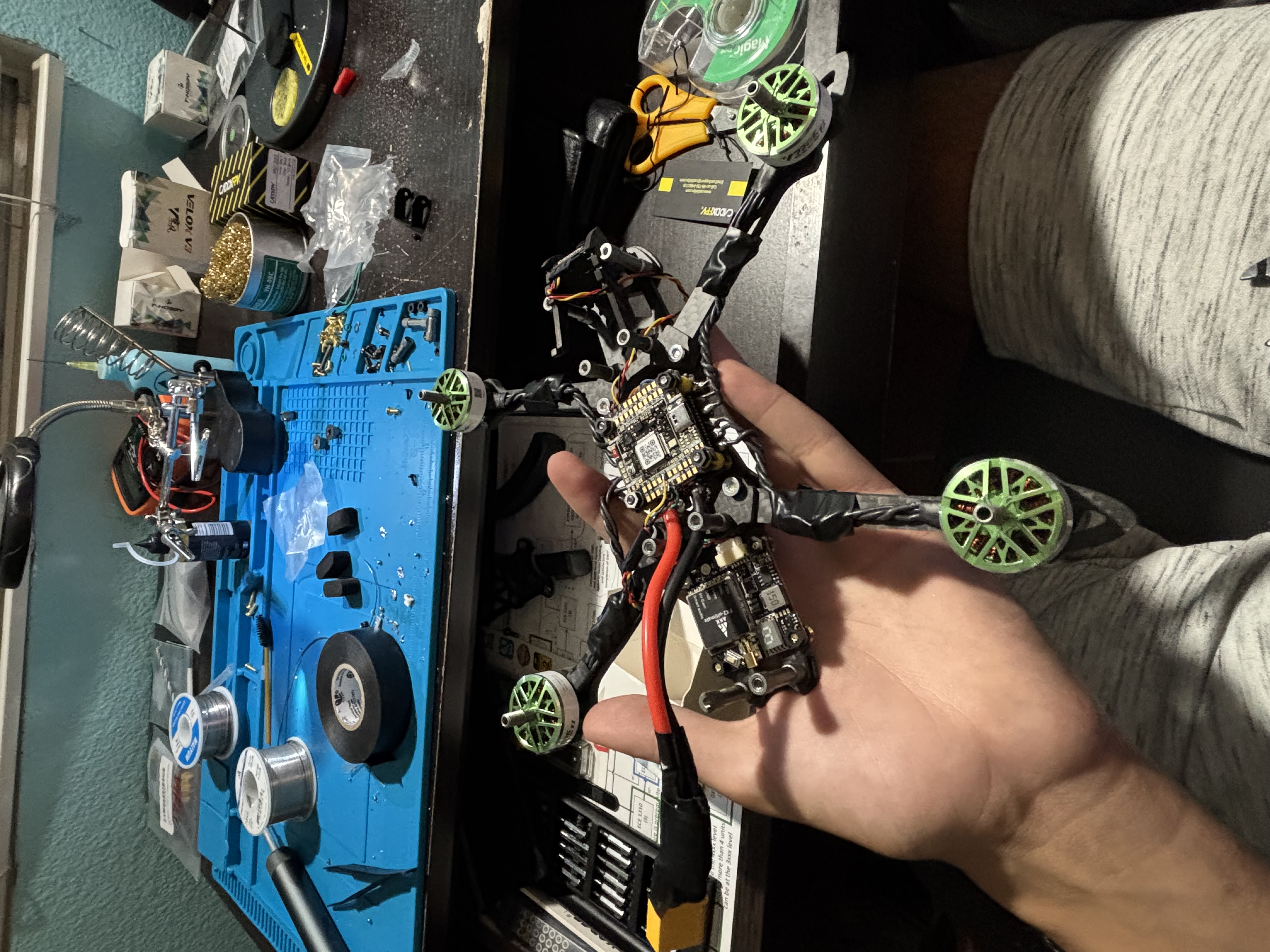 Top-down view of the assembled FPV quadcopter held over the workbench